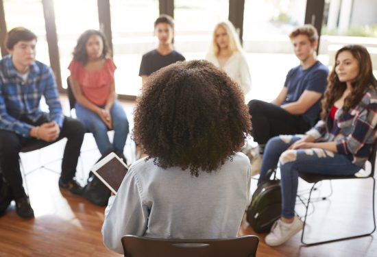 A teacher leading a discussion with high school students